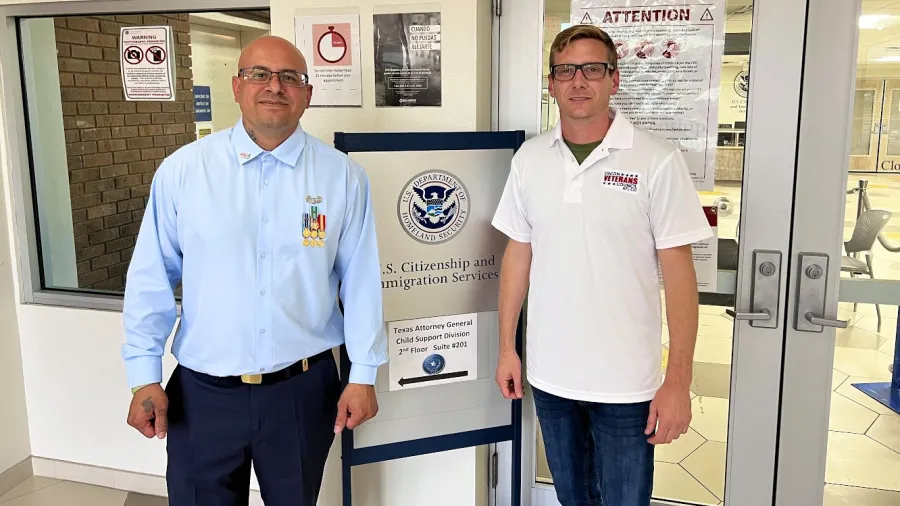 Photo of Ivan Ocon in front of U.S. Citizenship and Immigration Services sign, standing next to man from Union Veterans Council