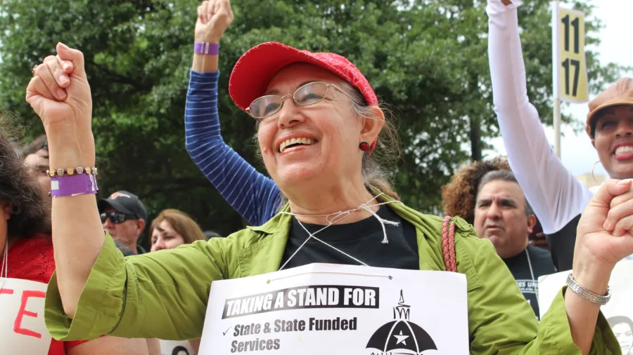 Union member holds her fist up at a rally